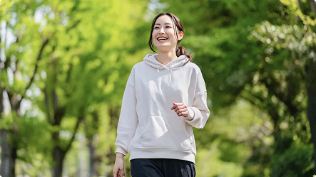 自然の中を笑顔でウォーキングする女性