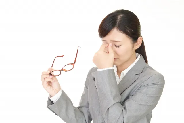 目を抑える女性の写真